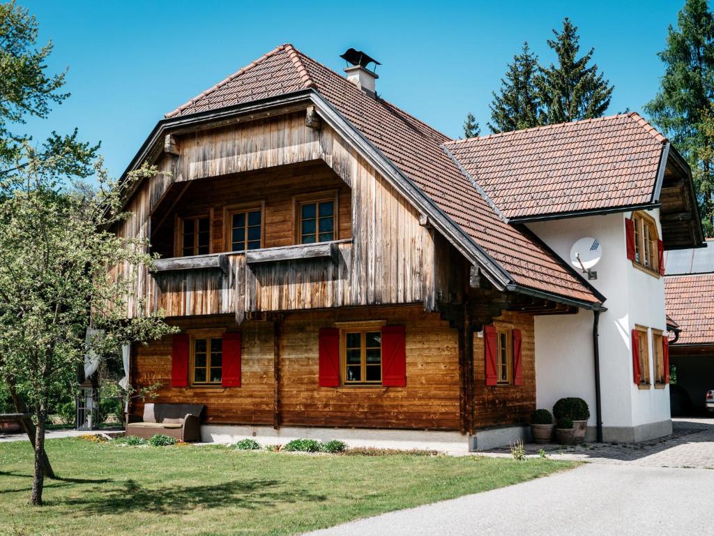 een oud houten huis met rode luiken bij Holiday Home amid the walking and cycling area of Petzenland in Unterlibitsch