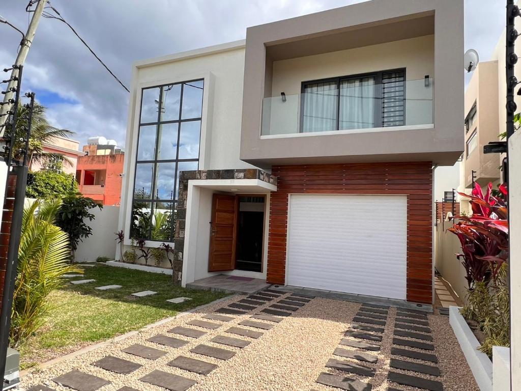 une maison moderne avec une porte de garage blanche. dans l'établissement Villa Aussee Mauritius, à Trou aux Biches