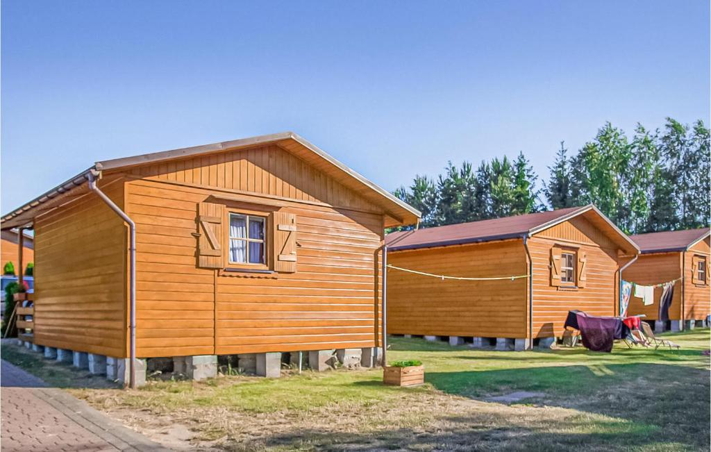 a row of wooden homes in a yard at Awesome Home In Jaroslawiec With 1 Bedrooms in Jarosławiec