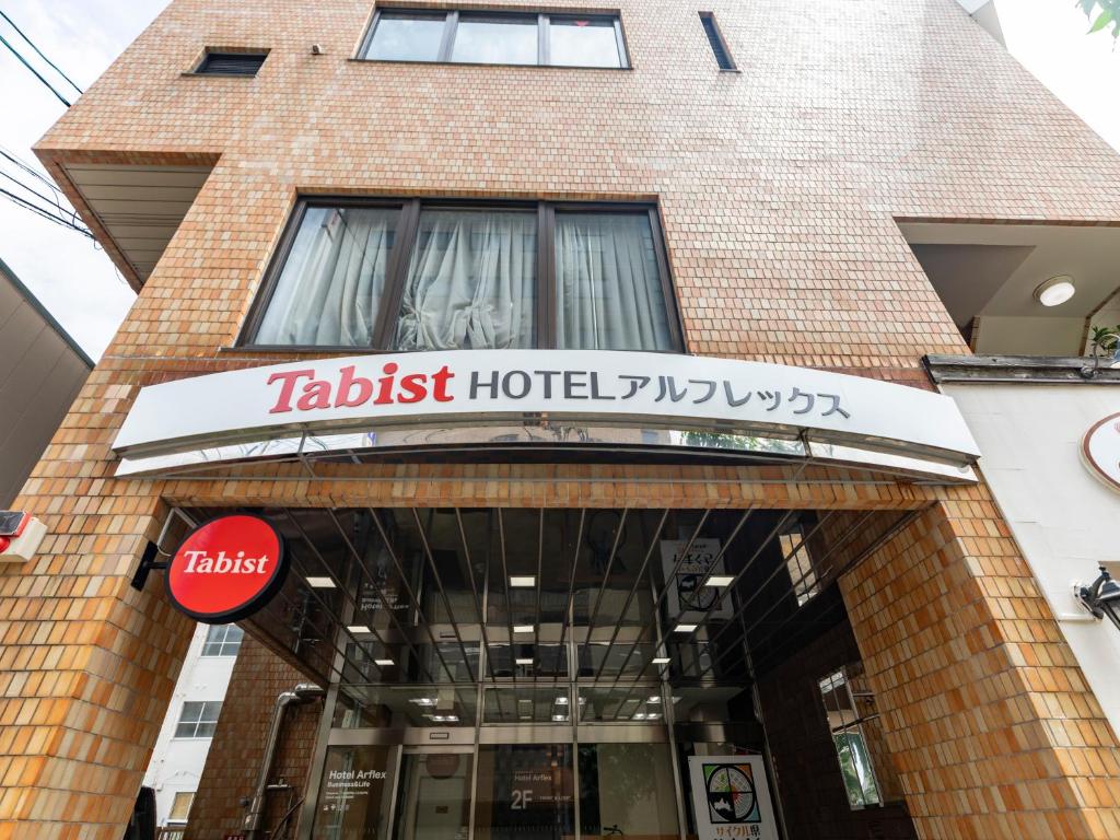 un panneau d'hôtel à l'avant d'un bâtiment dans l'établissement Tabist HotelArflex Tokuyama Station, à Shunan