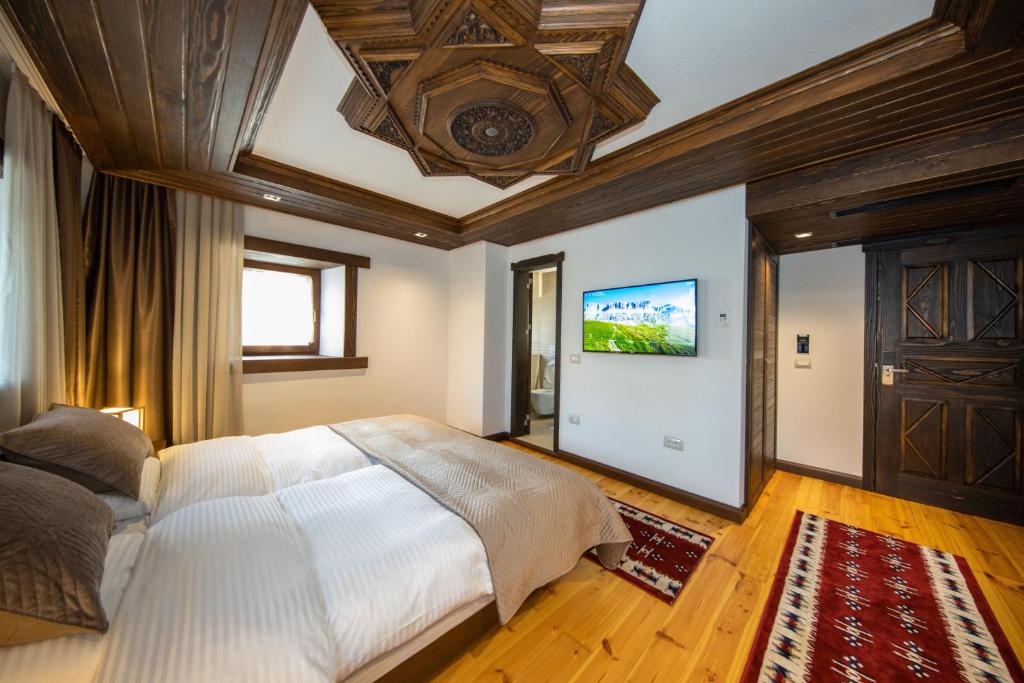 a bedroom with a large bed and a flat screen tv at Hotel - Kulla e Zenel Beut in Peje
