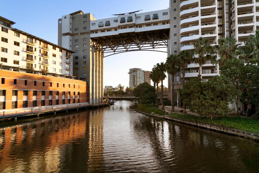 un puente sobre un río en una ciudad con edificios en Knightsbridge 407 by HostAgents, en Ciudad del Cabo