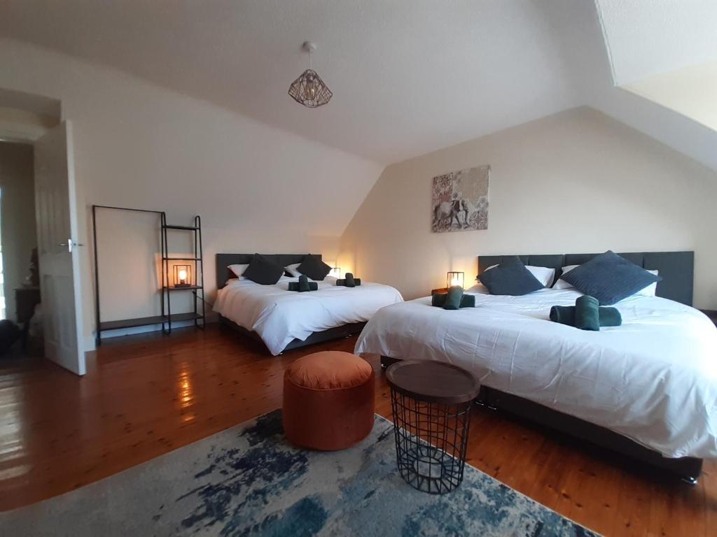 a large bedroom with two beds and a rug at Carvetii - Laurel House - 2 bed House sleeps up to 8 