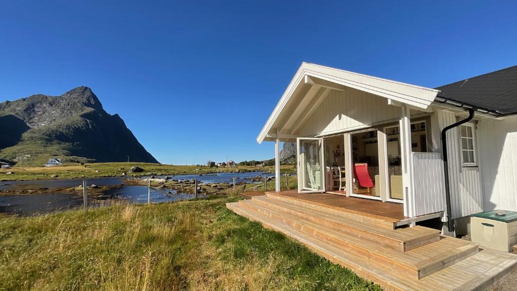 a house with a deck with a mountain in the background at Mountain Panorama in Bøstad