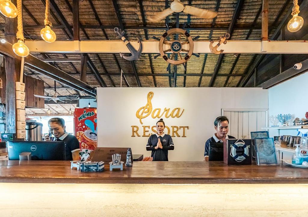 a group of men standing behind a bar in a restaurant at Sara Resort in Koh Rong Sanloem