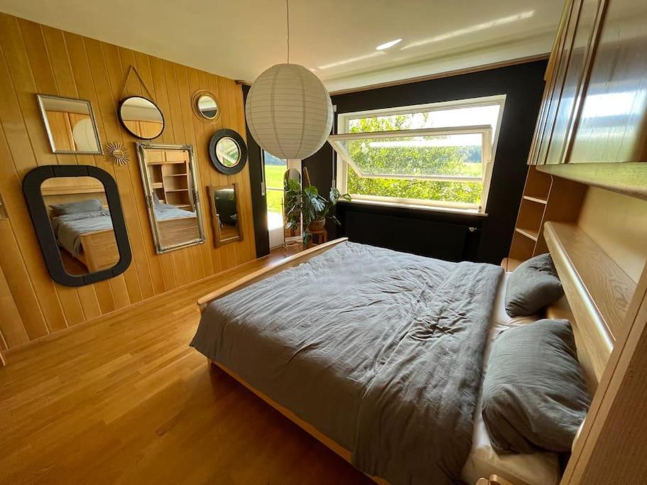 Un dormitorio con una cama grande y una ventana en Apartment AusZeit - Natur Pur - mitten im Grünen, 