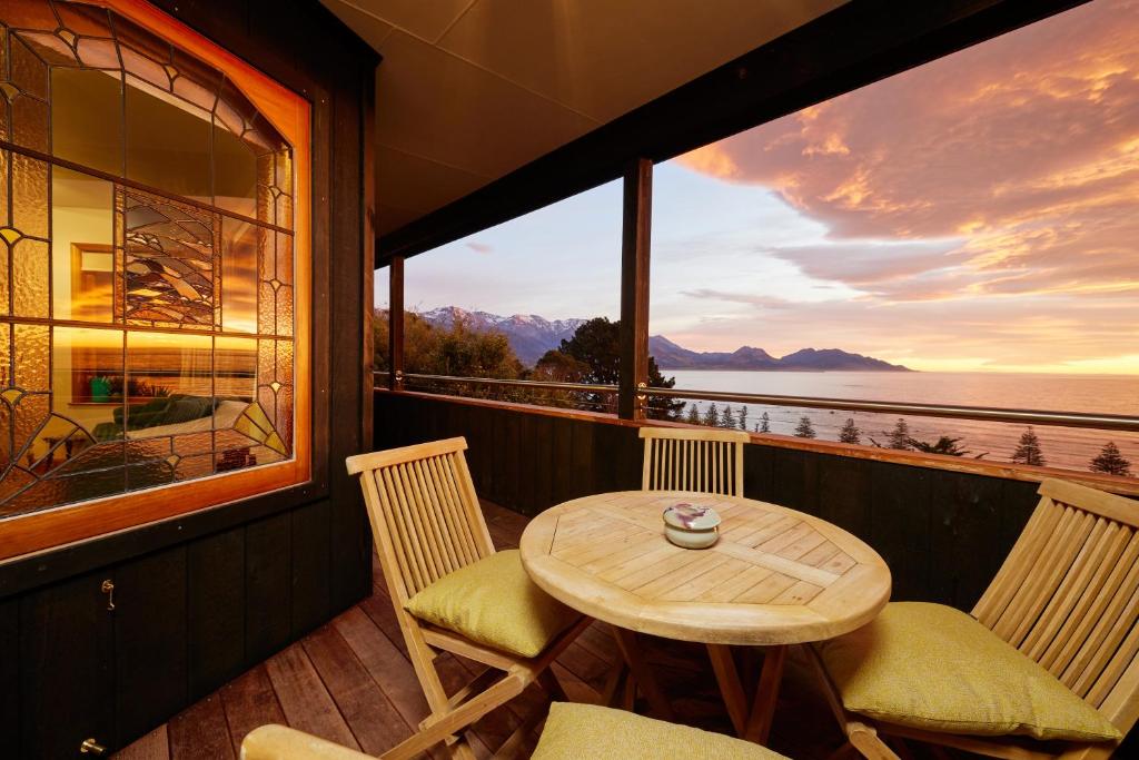 a table and chairs on a balcony with a view of the ocean at A Room With a View in Kaikoura