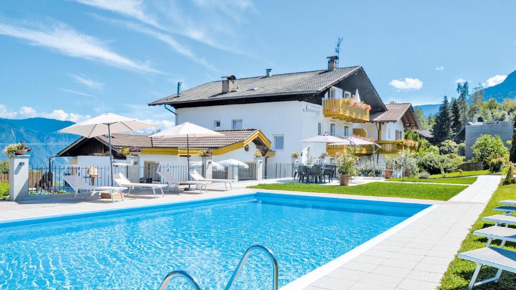 une villa avec une piscine en face d'une maison dans l'établissement Residence Ferienwohnungen Sonnegg, à Vollan