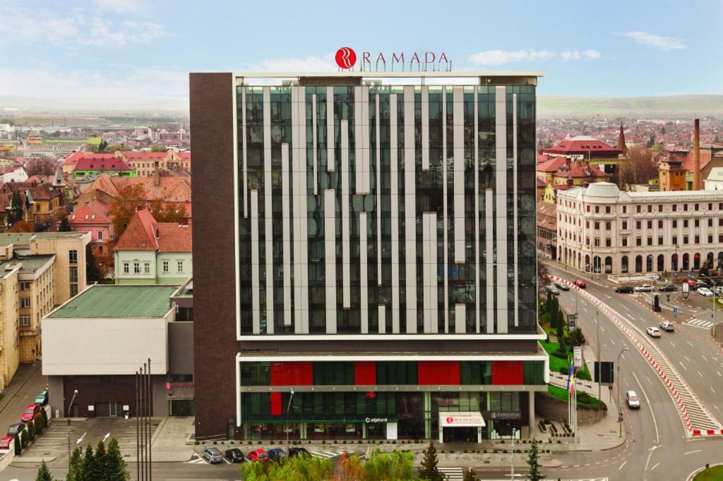 Un palazzo alto con un cartello sopra. di Ramada Sibiu Hotel a Sibiu