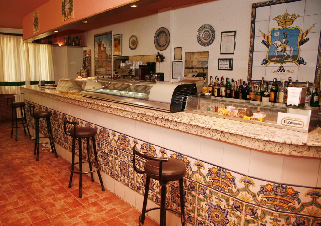 a bar in a restaurant with a counter and stools at Hostal Cuatro Esquinas in Ejea de los Caballeros