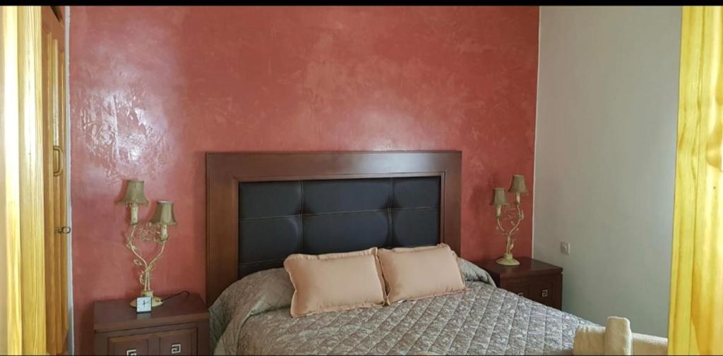 1 dormitorio con cama y pared roja en Piso de Alquiler cómodo y a 5 min de Atocha Madrid, en Madrid