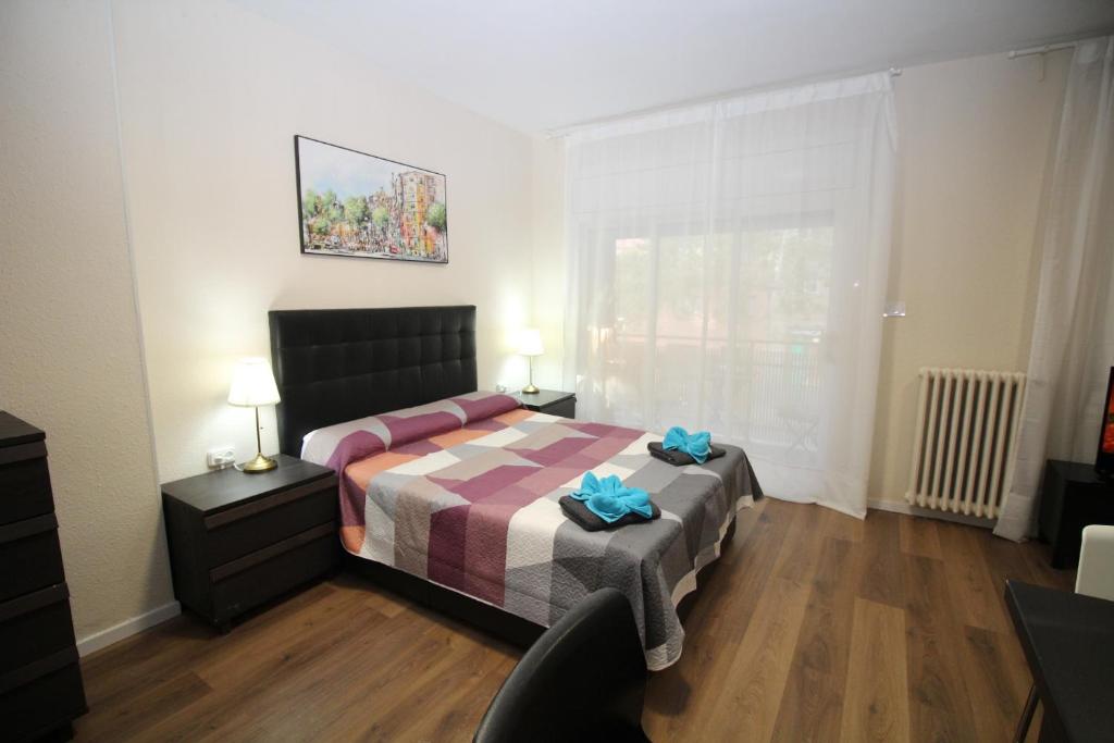 ein Schlafzimmer mit einem Bett, einem Stuhl und einem Fenster in der Unterkunft Urgel habitaciones in Barcelona