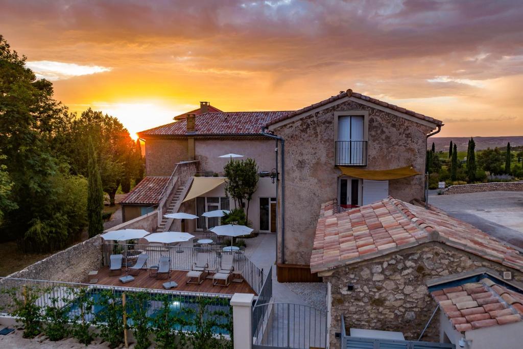a house with a sunset in the background at Villa Sainte Anne in Gigondas