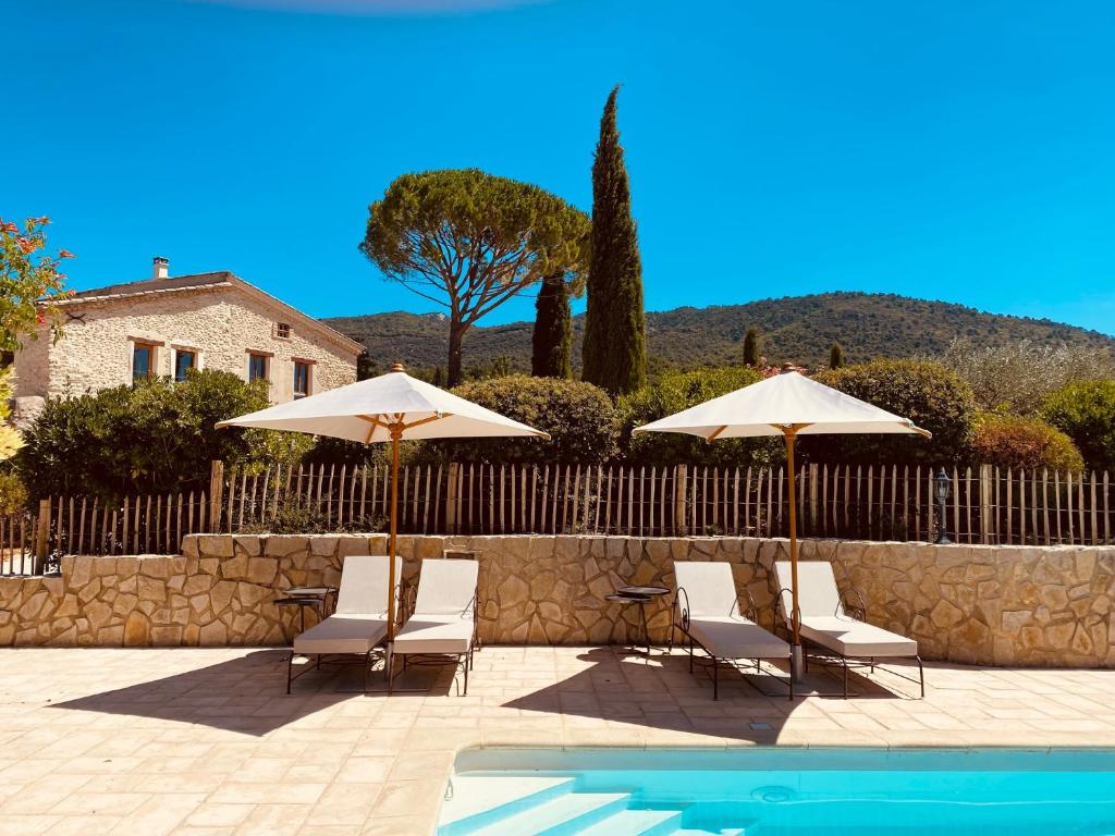 un grupo de sillas y sombrillas junto a una piscina en La Bastide des Oliviers Provence - Mirabel aux Baronnies en Mirabel-aux-Baronnies