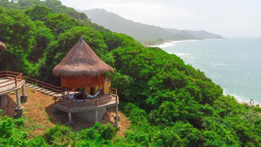 a small building on a hill next to the ocean at Ecohabs Tequendama Playa Cañaveral Parque Tayrona in El Zaino