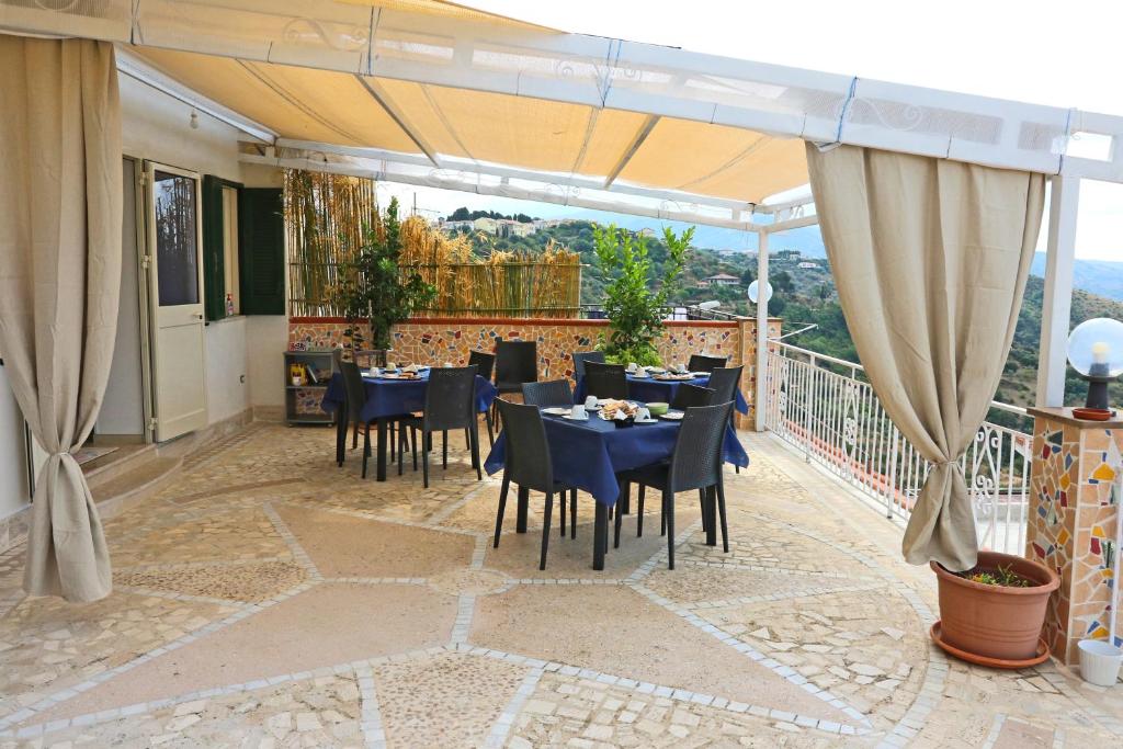 un restaurante con mesas y sillas en un balcón en CARPE DIEM B&B en Castellabate