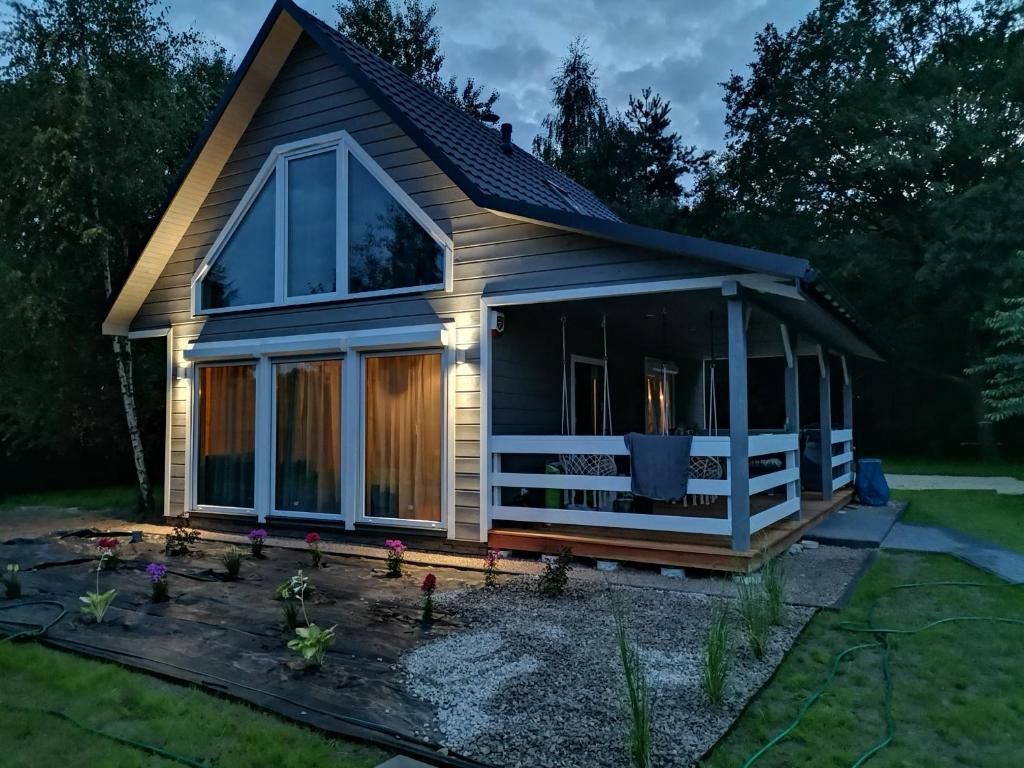 a tiny house with a porch and a deck at Dziki zakątek Piskornia dom z balią jacuzzi in Piskornia