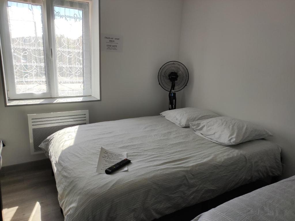 a bedroom with a bed with a remote control on it at 16 rue des Déportés in Charmes
