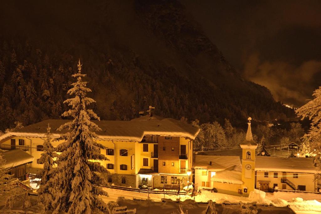 a building with a christmas tree in front of a mountain at Residence Bellevue in Antey-Saint-André