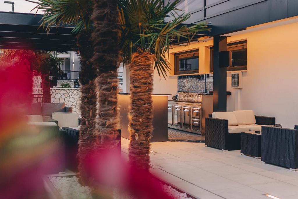 a palm tree in the lobby of a restaurant at Cool Šilo Appartement Resort in Šilo