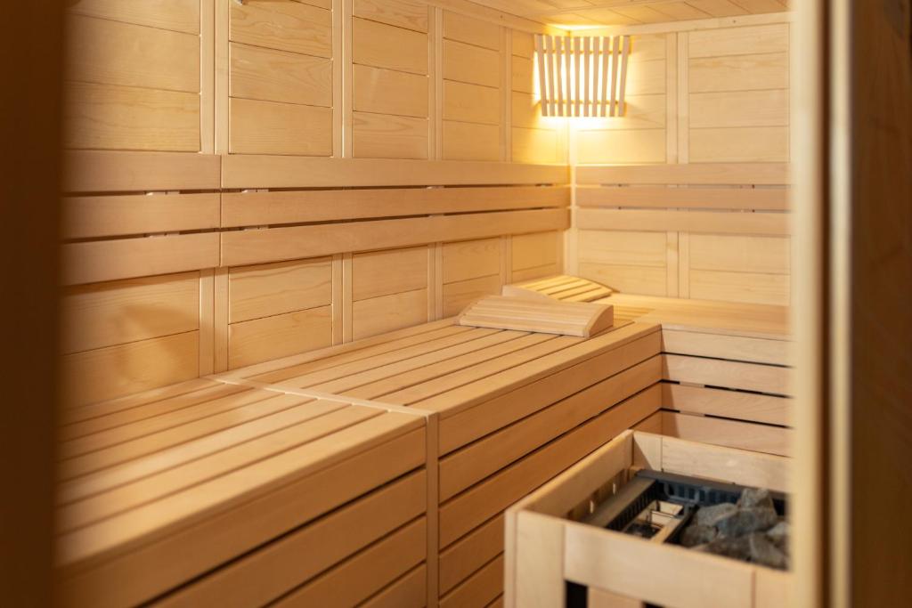 a sauna with wooden cabinets and a chandelier at Cool Šilo Appartement Resort in Šilo