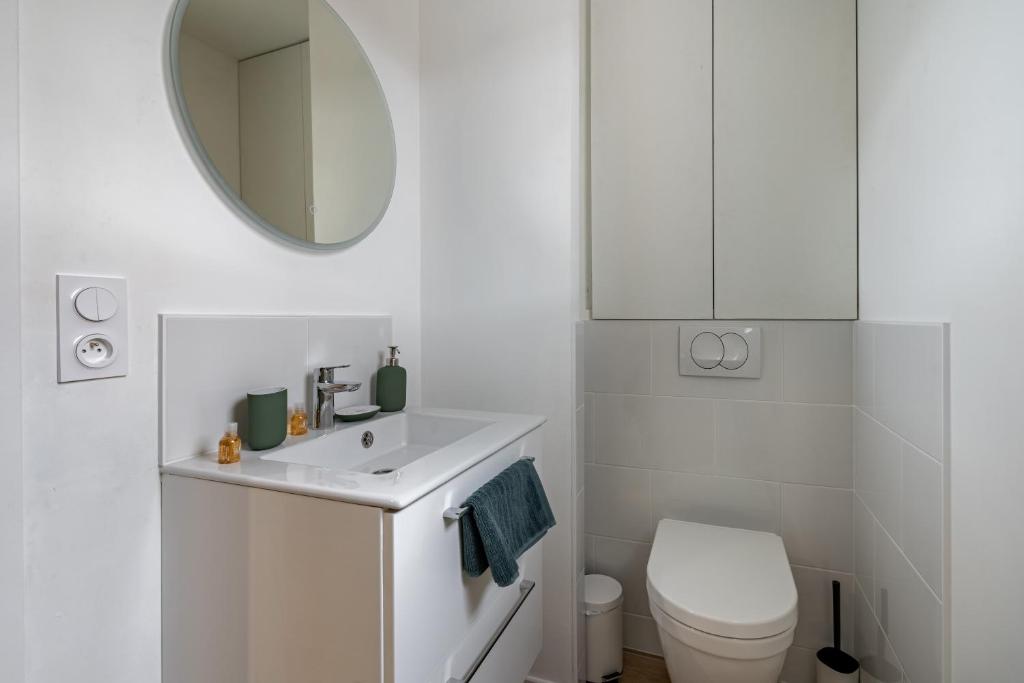 a white bathroom with a toilet and a mirror at Welcome perche ! Appartements 3 étoiles à NOGENT le Rotrou in Nogent-le-Rotrou