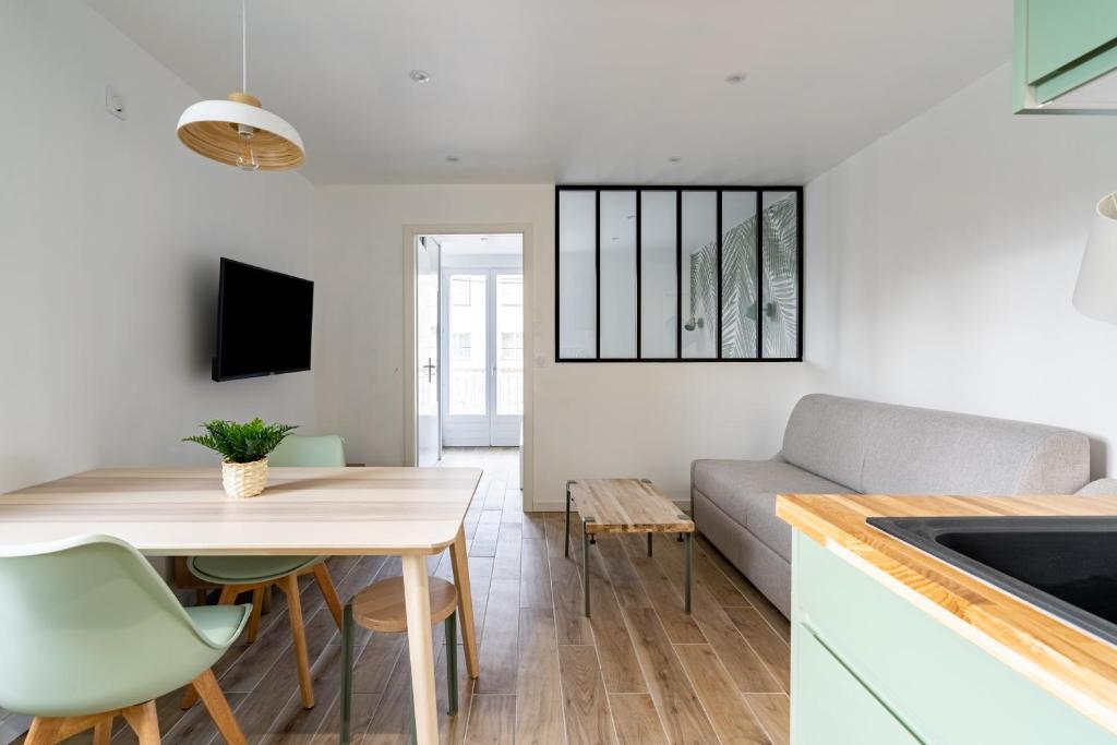 a kitchen and living room with a table and a couch at Welcome perche ! Appartements 3 étoiles à NOGENT le Rotrou in Nogent-le-Rotrou