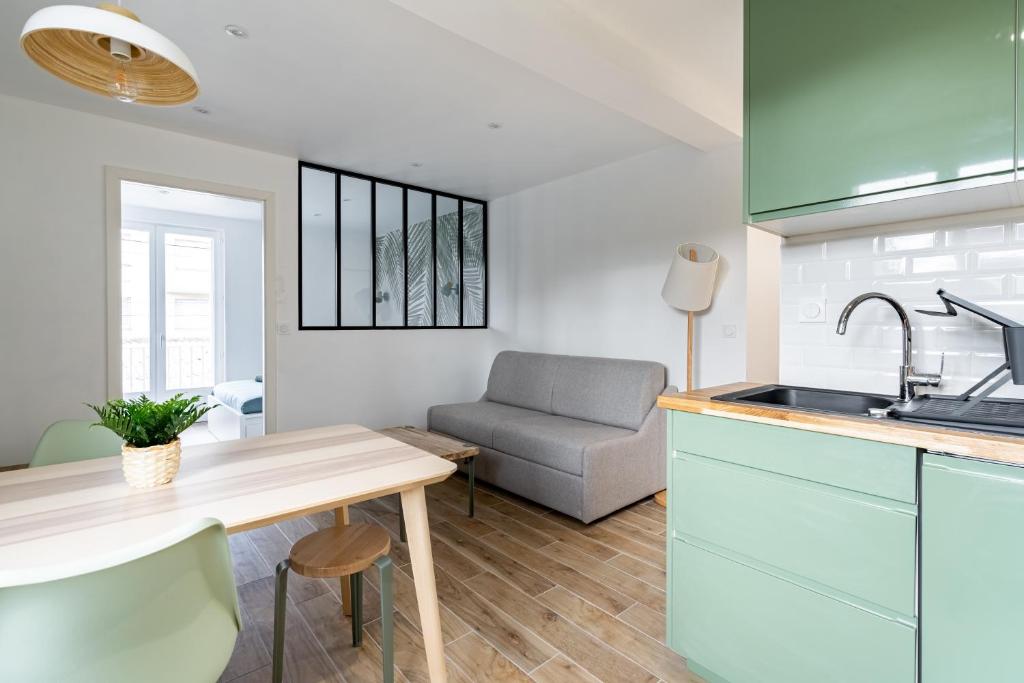 a kitchen with a table and a couch in a room at Welcome perche ! Appartements 3 étoiles à NOGENT le Rotrou in Nogent-le-Rotrou