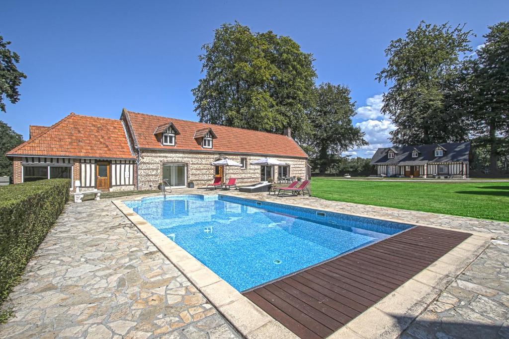 a swimming pool in front of a house at Clos Celeste - campagne d Etretat avec piscine et spa in Écrainville