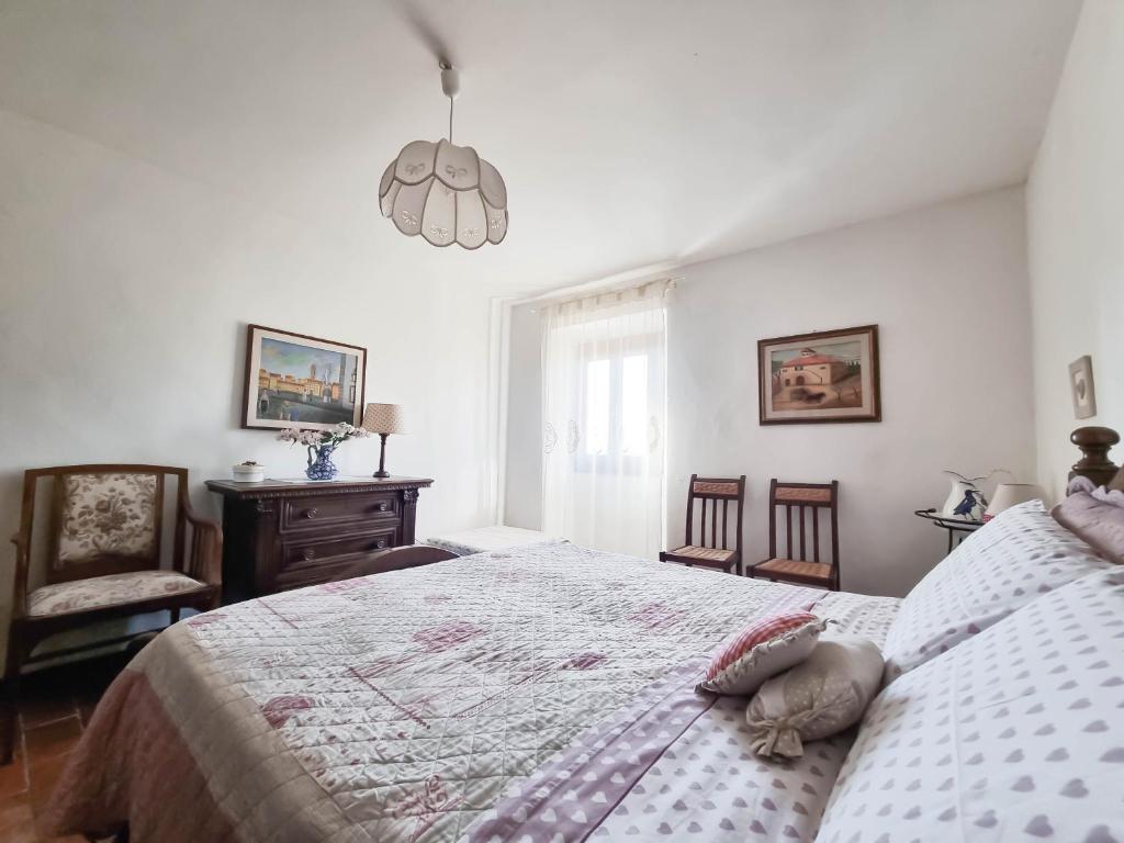 a bedroom with a large bed and a chandelier at Appartamenti Tortorella in Pelago