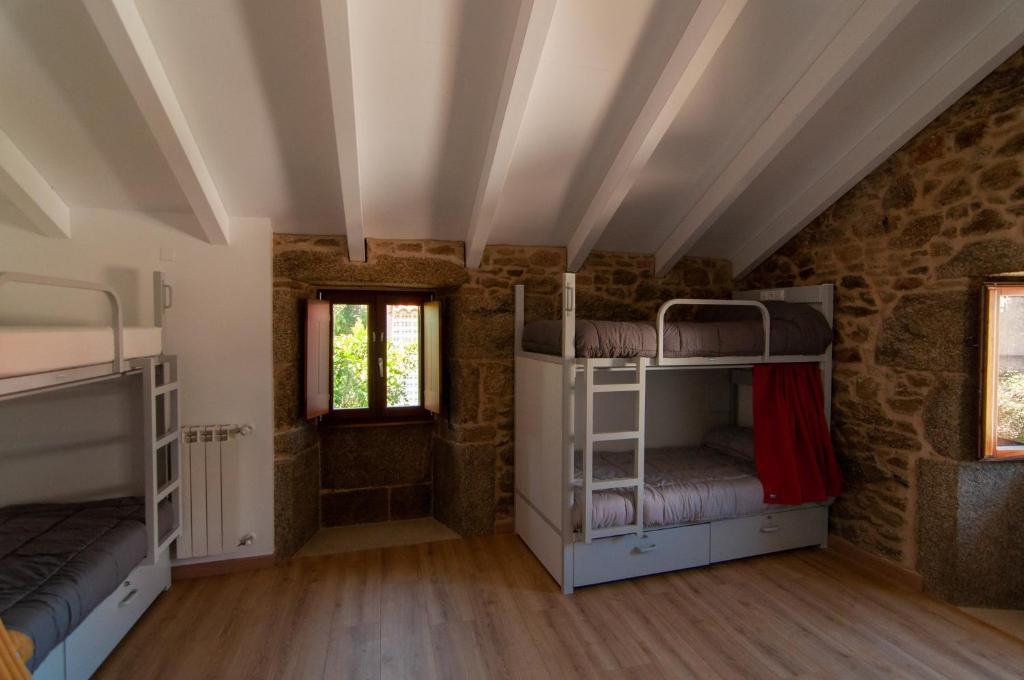 Habitación con literas en un edificio de piedra. en A Casa Do Boi, en Amés