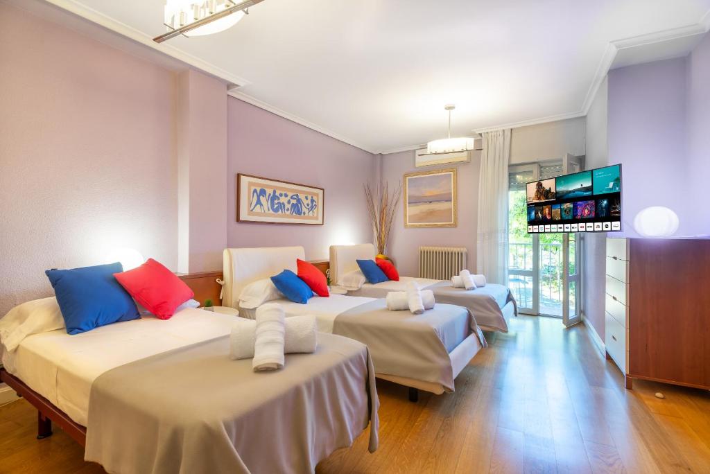 a room with four beds with a flat screen tv at Apartamento VIRGEN DEL VALLE in Cenicero