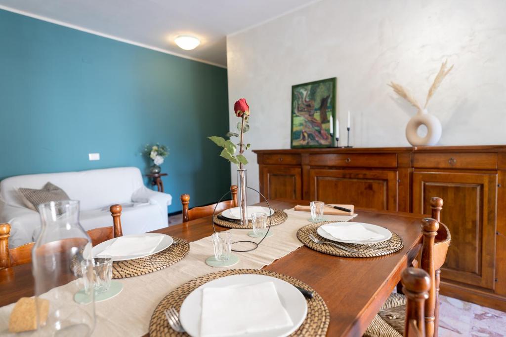 uma sala de jantar com uma mesa de madeira com pratos em [VIA CRISPI] Grande e comodo in zona tranquilla. em Pietra Ligure