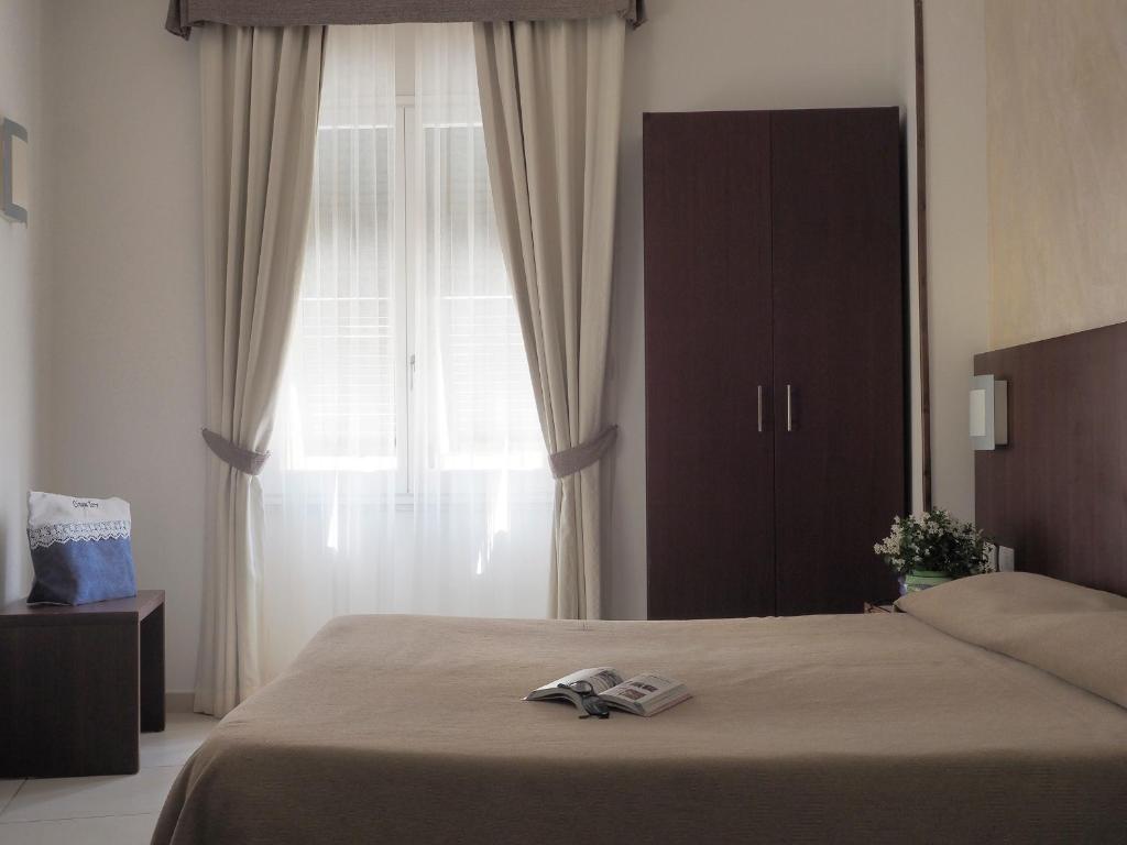 a bedroom with a bed and a large window at Hotel Margherita in Monterosso al Mare