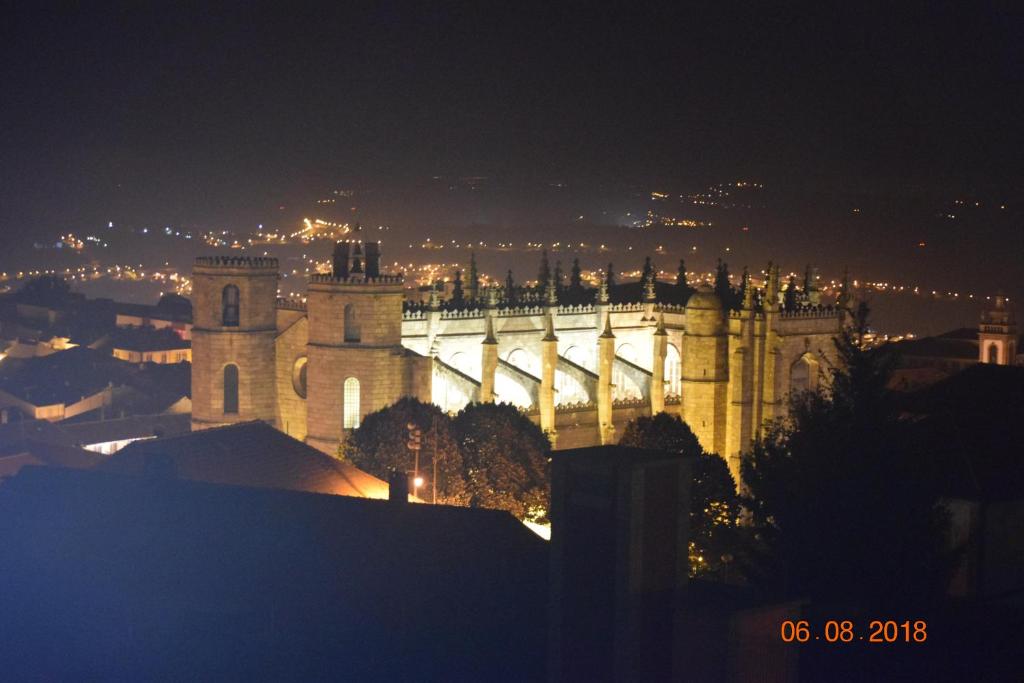 a castle at night with a city in the background at zélu apartamento centro da Guarda in Guarda
