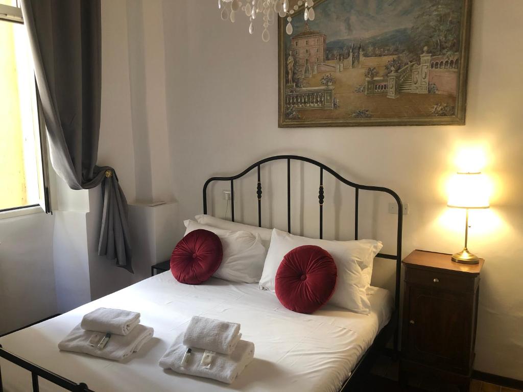 sypialnia z łóżkiem z czerwonymi poduszkami w obiekcie ROMAN APARTMENT in TRASTEVERE w Rzymie
