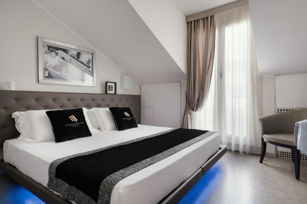 a bedroom with a large white bed with black and white pillows at Montenapoleone Suites in Milan