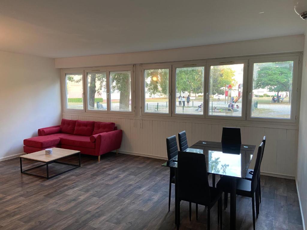 sala de estar con sofá rojo y mesa en Bel appartement spacieux, lumineux avec parking en Ris-Orangis