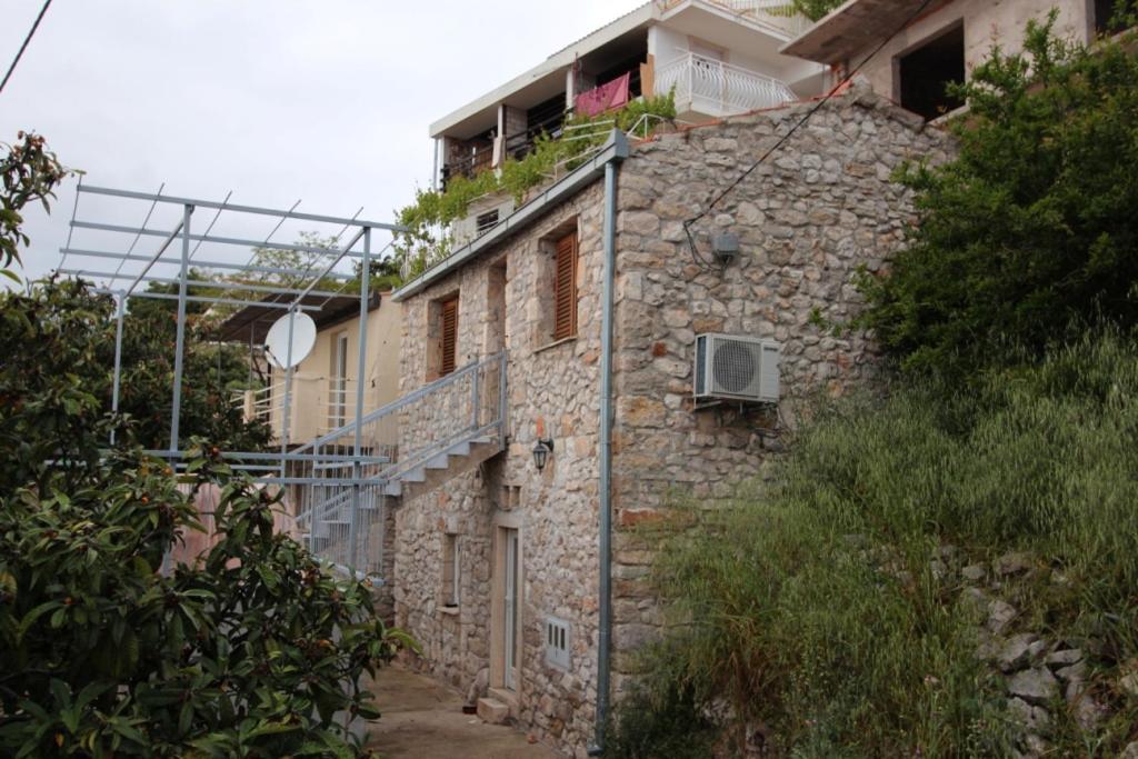 - un ancien bâtiment en pierre avec un balcon au-dessus dans l'établissement Robin Borje, à Orebić