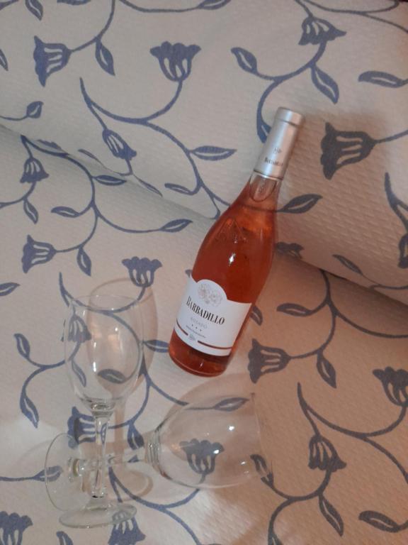 una bottiglia di vino accanto a due bicchieri su un tavolo di Hospedaje Benacazon A49 a Benacazón