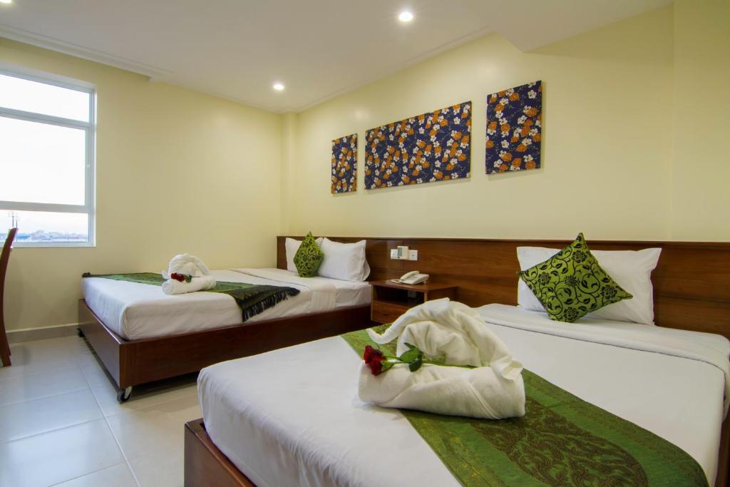 Postel nebo postele na pokoji v ubytování Rose Emerald Hotel