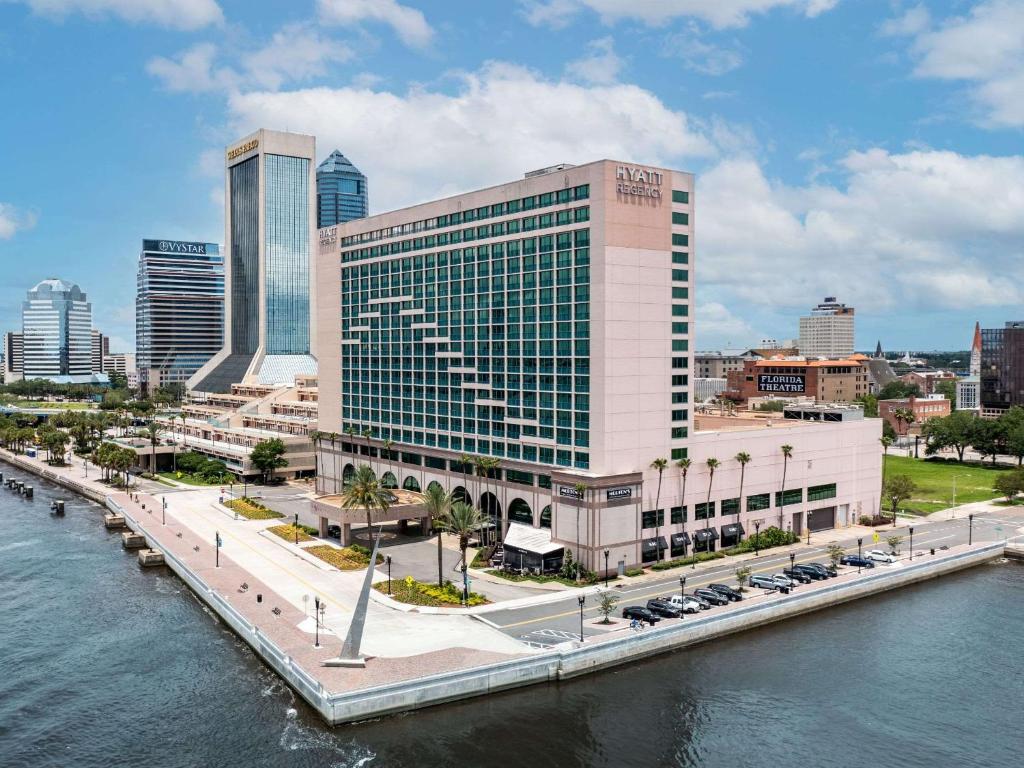 un grande edificio accanto a un corpo idrico di Hyatt Regency Jacksonville Riverfront a Jacksonville