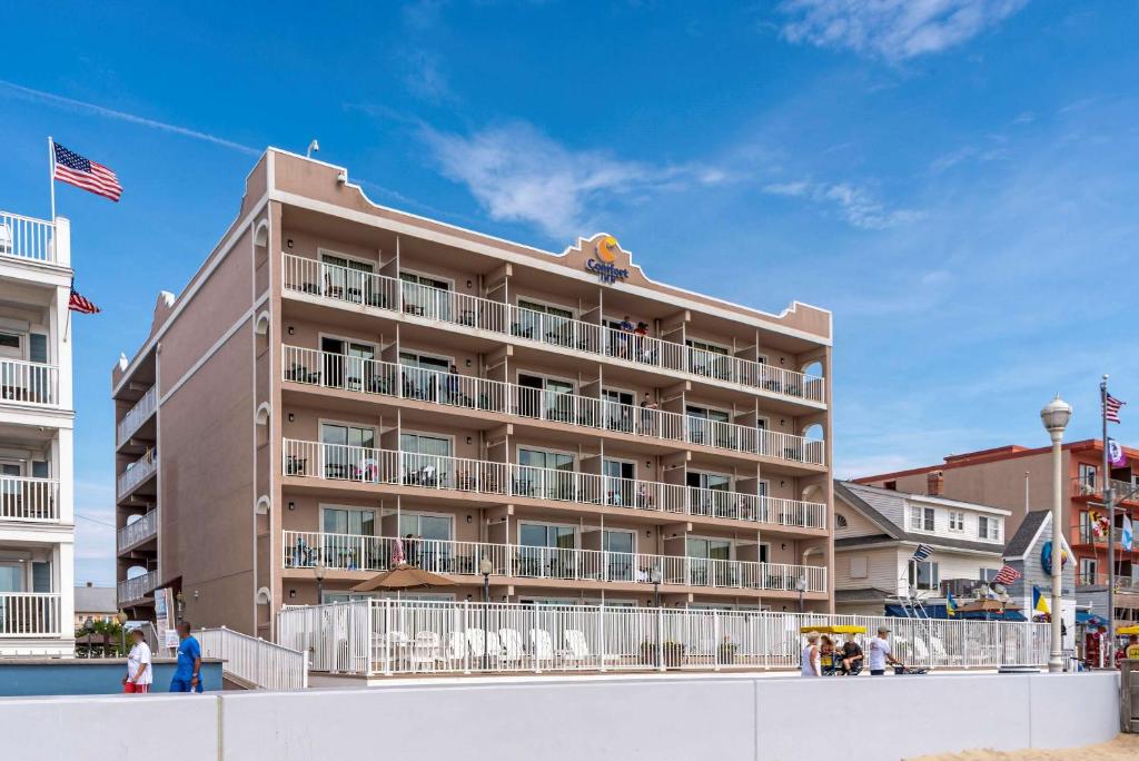 a large building on the beach with people in front of it at Comfort Inn Ocean City Boardwalk in Ocean City
