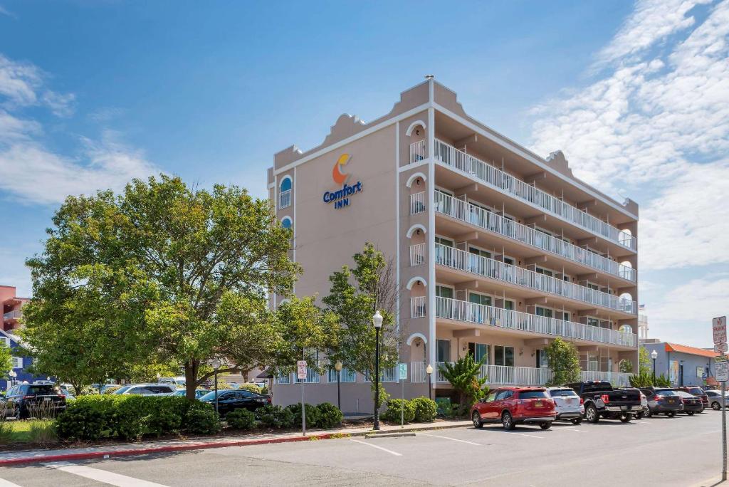 a hotel building with cars parked in a parking lot at Comfort Inn Ocean City Boardwalk in Ocean City