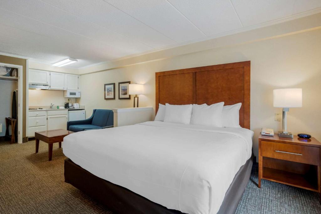 a bedroom with a large white bed and a blue chair at Comfort Inn Ocean City Boardwalk in Ocean City