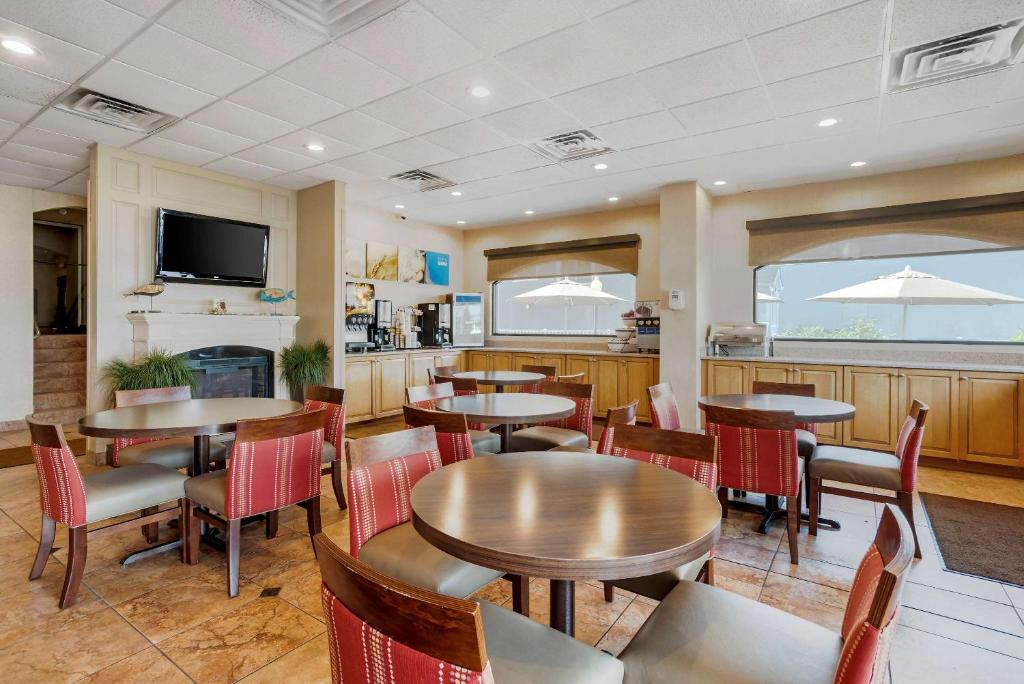 a restaurant with tables and chairs and a kitchen at Comfort Inn Ocean City Boardwalk in Ocean City