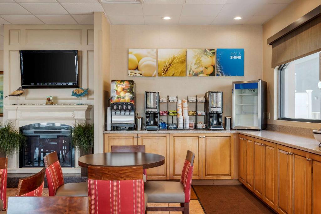 a restaurant with a table and chairs and a tv at Comfort Inn Ocean City Boardwalk in Ocean City
