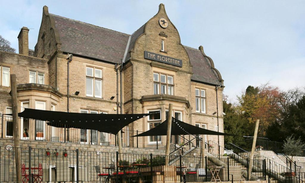 un vieux bâtiment en brique avec un panneau. dans l'établissement The Florentine, à Sheffield