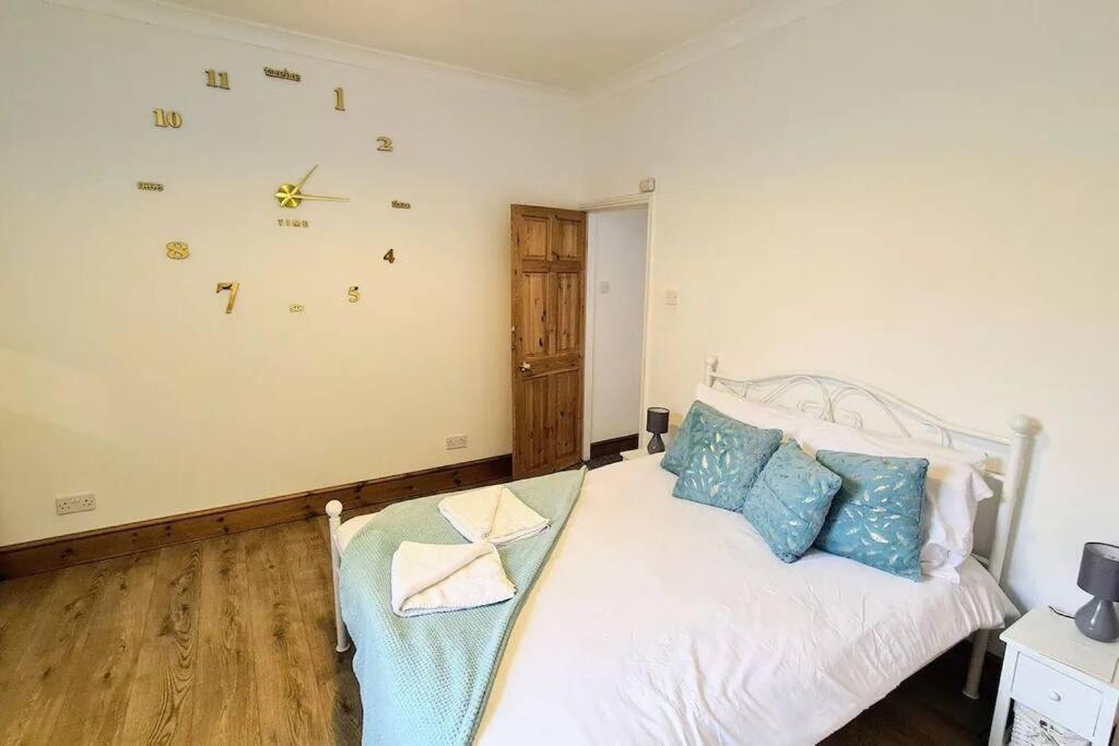 1 dormitorio con cama blanca y almohadas azules en 2 bedroom Victorian canal side terrace house., en Hebden Bridge