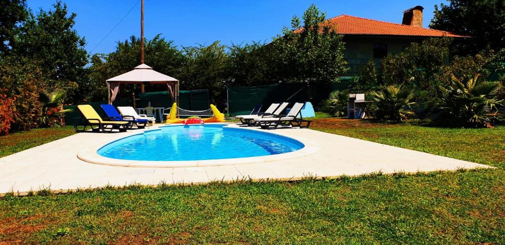 una pequeña piscina con sillas y cenador en Quinta de Carvalhal - Casa de Campo en Guimarães